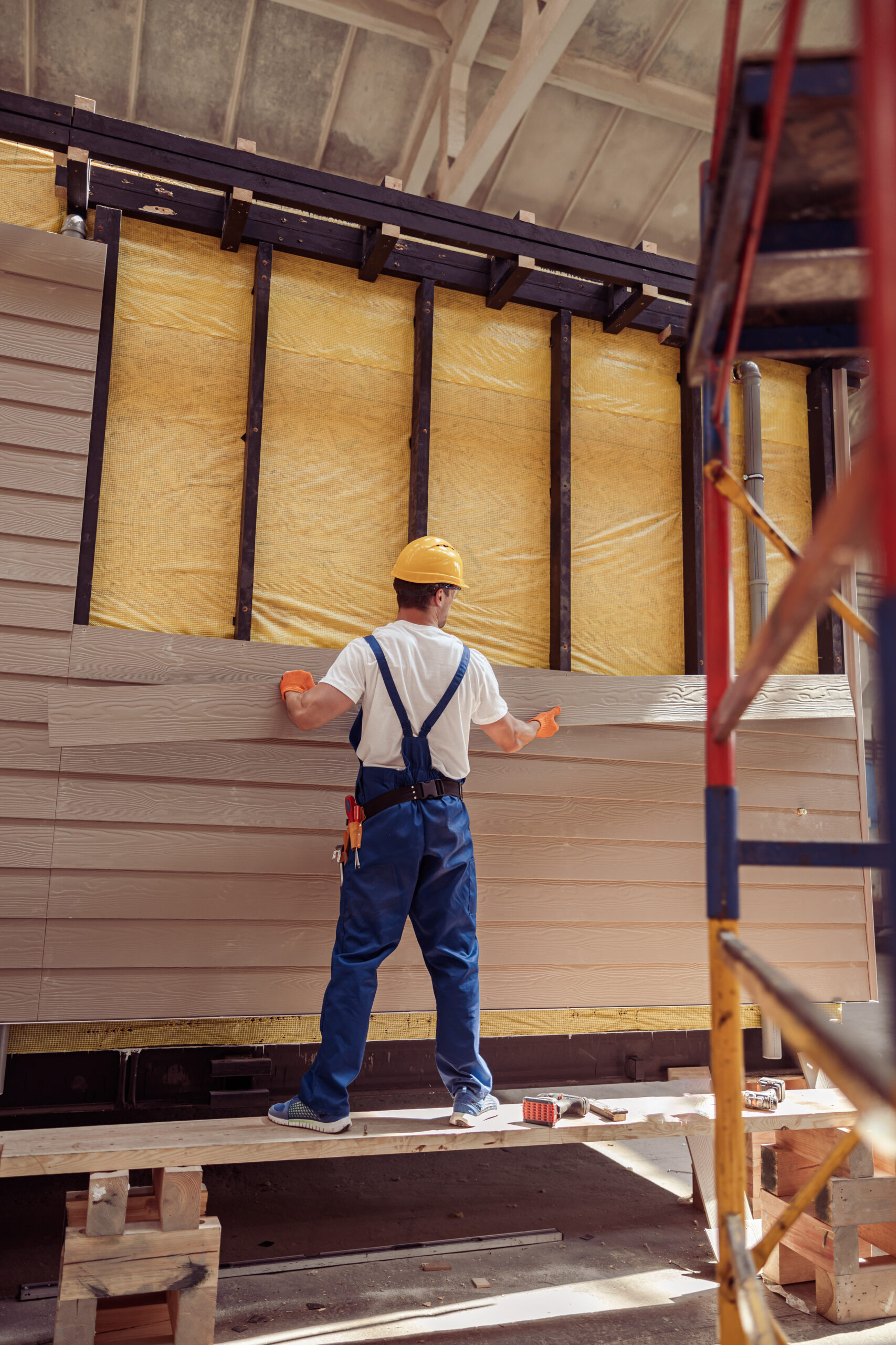 Male builder building house at construction site